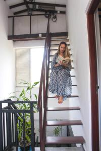 a woman sitting on the stairs reading a book at Unawatuna Guest in Unawatuna