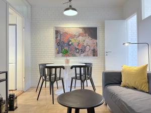 - un salon avec une table, des chaises et un canapé dans l'établissement Three Bedroom Apartment In Valby, Langagervej 66,, à Copenhague