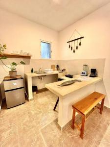 uma cozinha com uma mesa e um balcão num quarto em Casa Sabina 2 • Cosy Apt. with Wifi & TV em Ilha Holbox