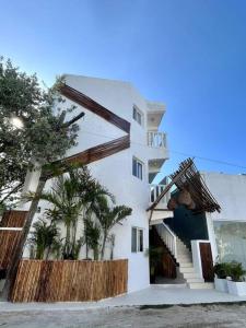 un edificio blanco con palmeras delante en Casa Sabina 2 • Cosy Apt. with Wifi & TV, en Isla Holbox