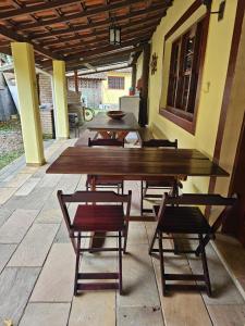 una gran mesa de madera y sillas en un patio en Pousada da Mary en Ubatuba