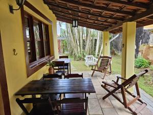 a porch with a wooden table and chairs on a patio at Pousada da Mary in Ubatuba