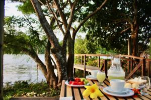 a picnic table with food and drinks and a bottle of milk at Marcone Lima - Chalés in Barreirinhas