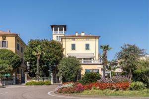 a building with a clock tower in the middle of a street at Villa Liberty - next to Fraglia Vela Riva in Riva del Garda