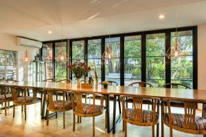 una grande sala da pranzo con un grande tavolo in legno e sedie di Villa 88 Nimman-Chiang Mai a Chiang Mai