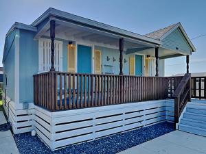 a small blue house with a wooden deck at Tranquil Cove in Port Aransas