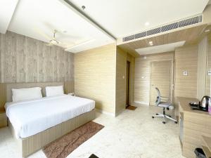 Schlafzimmer mit einem Bett, einem Schreibtisch und einem Stuhl in der Unterkunft Hotel TBS ! PURI all-rooms-sea-view fully-air-conditioned-hotel with-lift-and-parking-facility breakfast-included in Puri