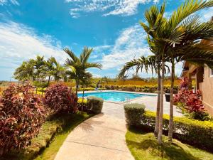 a swimming pool with palm trees next to a building at Jhadano 3br Pool & Gym Free Shuttle Washer, Dryer in Florence Hall