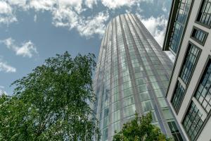 un edificio alto con un árbol delante de él en Olympic Park Apartments, en Londres