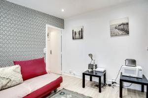 ein Wohnzimmer mit einem Sofa und einer Mikrowelle in der Unterkunft 9 min de l'hippodrome avec terrasse privée in Suresnes