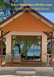 a pavilion with glass doors and chairs on a beach at Kradan Beach Resort in Koh Kradan