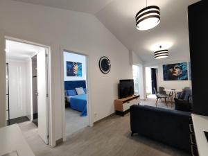 een woonkamer met een bank en een slaapkamer bij Bungalow "BAHIA AZUL" in Playa del Inglés