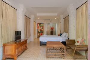a bedroom with a bed and a tv and a couch at Baan Tawai Lanna Resort in Hang Dong