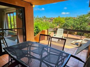 eine Terrasse mit einem Glastisch und Stühlen auf dem Balkon in der Unterkunft San Lameer 3125 by Top Destinations Rentals in Southbroom