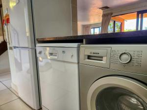 eine Waschmaschine und ein Kühlschrank in der Küche in der Unterkunft San Lameer 3125 by Top Destinations Rentals in Southbroom