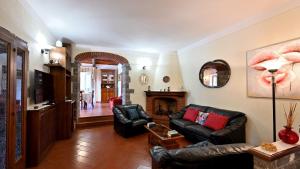 a living room with black leather furniture and a fireplace at Angolino in Radda in Chianti