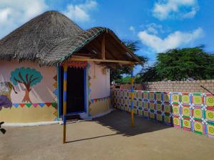 a small house with a tree painted on it at White Rann Homestay in Dhordo