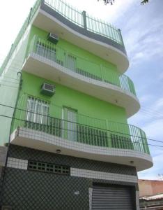 a tall green building with balconies on it at Hotel Shalom in Juazeiro do Norte
