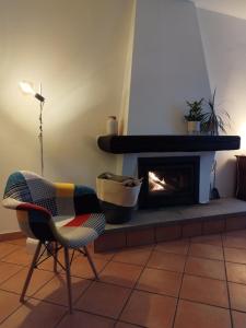 ein Wohnzimmer mit einem Stuhl und einem Kamin in der Unterkunft casa pungitopo in Bedigliora