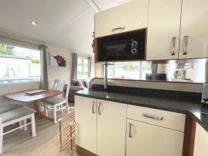 a kitchen and dining area of a caravan at Pass the Keys Charming and Cosy Holiday Home in Beautiful Park in Beattock