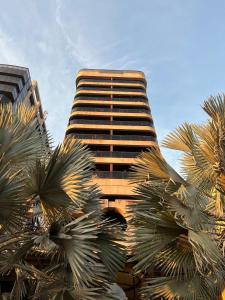 a tall building with palm trees in front of it at Ipanema Flat - Vieira Souto 500 in Rio de Janeiro