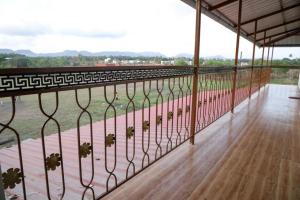 einen Blick vom Balkon eines Hauses mit einem Zaun in der Unterkunft Mokalbaug Beach Resort in Nagaon