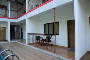 Habitación con 2 sillas y balcón con mesa. en Mokalbaug Beach Resort, en Nagaon