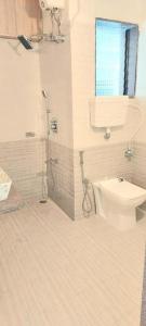La salle de bains est pourvue de toilettes, d'une douche et d'une fenêtre. dans l'établissement Mokalbaug Beach Resort, à Nagaon