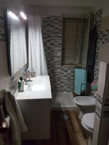 ein Badezimmer mit einem Waschbecken, einem WC und einer Badewanne in der Unterkunft Parco La Bruca Villetta Margherita 800 mt dal mare in Cipollina