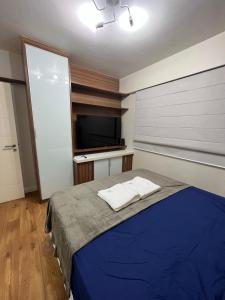 a bedroom with a bed and a flat screen tv at Flat Barra - Parque das Rosas in Rio de Janeiro