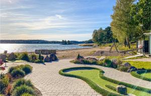 a stone walkway with a golf course in front of a lake at 1 Bedroom Lovely Home In Trosa in Trosa