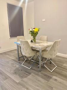 a table with chairs and a vase of flowers on it at Family House in Liverpool