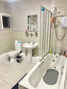 a bathroom with a tub and a toilet and a sink at Family House in Liverpool