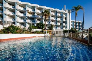 a swimming pool in front of a large building at GP127 apartman Tenerife in San Miguel de Abona