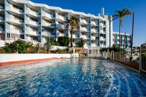 a swimming pool in front of a large building at GP127 apartman Tenerife in San Miguel de Abona