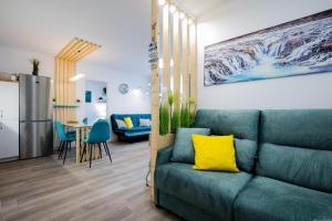 sala de estar con sofá verde y cocina en GP127 apartman Tenerife, en San Miguel de Abona