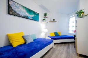 a room with two beds with blue and yellow pillows at GP127 apartman Tenerife in San Miguel de Abona +22 photos