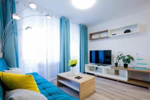 sala de estar con sofá azul y TV en GP127 apartman Tenerife en San Miguel de Abona