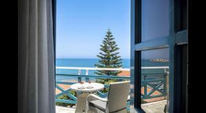 a room with a table and a christmas tree on a balcony at Petra Beach Hotel in Hersonissos
