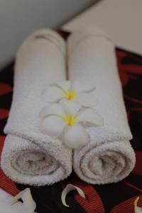 zwei Handtücher mit Blumen auf dem Bett in der Unterkunft D Plus B&B Negombo in Negombo