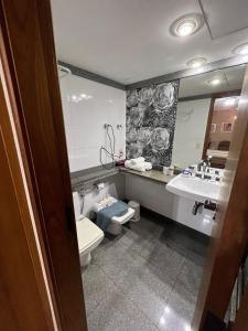 y baño con aseo, lavabo y espejo. en Flat Ipanema - Vieira Souto 500, en Río de Janeiro