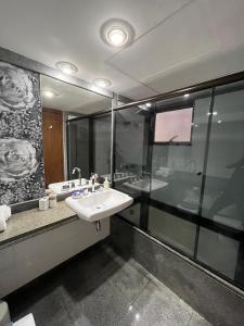 a bathroom with a sink and a large mirror at Flat Ipanema - Vieira Souto 500 in Rio de Janeiro