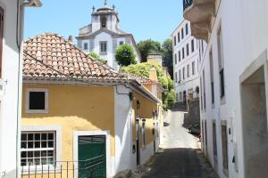 an alley in a town with white and yellow buildings at Sintra1012 Boutique Guesthouse in Sintra
