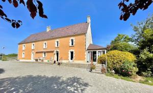 a large orange building with a driveway in front at le refuge in Castilly