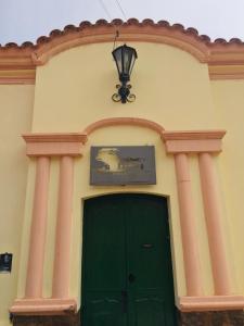 un edificio con una puerta verde y una luz sobre él en Postales del Tiempo en Tilcara