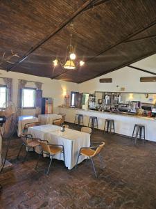 une salle à manger avec des tables et des chaises ainsi qu'un bar dans l'établissement Hotel Rural Portilla de Monfragüe, à Toril