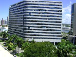a tall building with trees in front of it at Flat no Hotel Imperial Suites in Recife