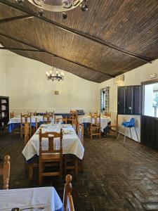 a dining room with tables and chairs and a ceiling at Hotel Rural Portilla de Monfragüe in Toril
