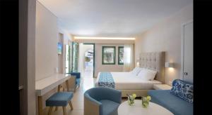 a hotel room with a bed and a table and chairs at Petra Beach Hotel in Hersonissos +27 photos