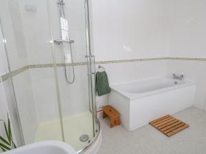 La salle de bains est pourvue d'une douche et d'un lavabo blanc. dans l'établissement Harbour Tales, à Weymouth 30 autres photos